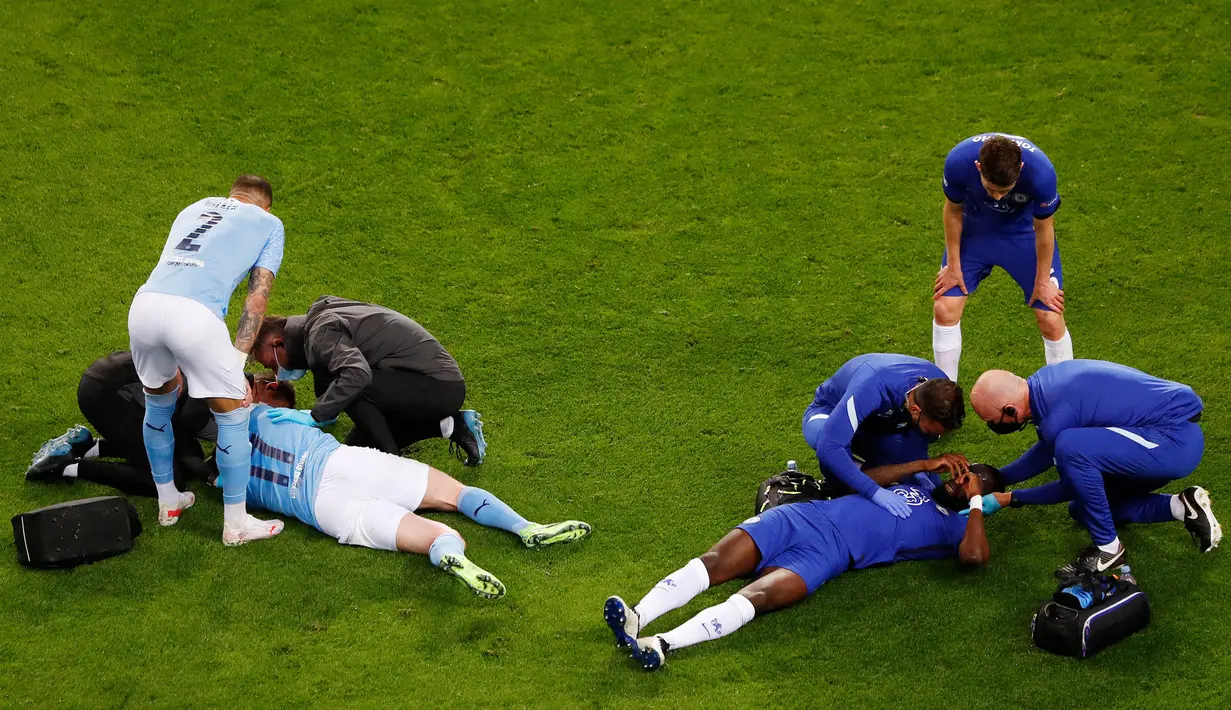 Antonio Rudiger (kanan) dan Kevin De Bruyne (kiri) menerima perawatan setelah bertabrakan selama pertandingan final Liga Champions antara Manchester City dan Chelsea di Stadion Dragao di Porto, Portugal, Sabtu (29/05/2021) atau Minggu dini hari WIB. (Foto: AFP/Pool/Susana Vera)