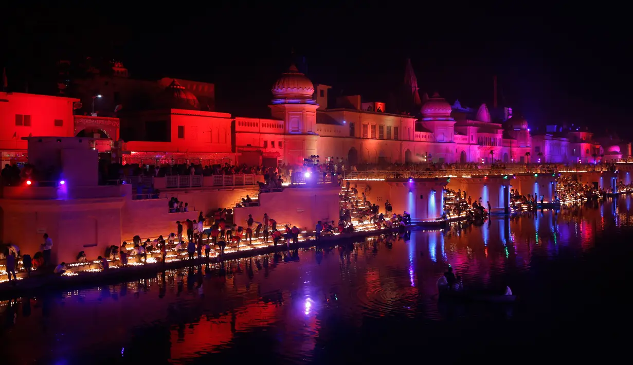Cahaya lampu dari tanah liat menerangi tepi Sungai Sarayu sebagai bagian dari perayaan Diwali di Ayodhya, , Selasa (6/11). Kota di utara India itu memecahkan rekor dunia Guinness setelah menyalakan 300.150 lampu selama 45 menit. (AP/Rajesh Kumar Singh)