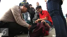 Anggota Polres Kepulauan Seribu memeriksa tas wisatawan di Kali Adem, Jakarta, Kamis (5/5). Razia tersebut sebagai bentuk pencegahan penyalahgunaan narkoba dan minuman keras. (Liputan6.com/Angga Yuniar) 