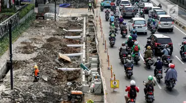 Pekerja mengerjakan proyek revitalisasi trotoar di Jalan Salemba Raya, Jakarta Pusat, Kamis (1/8/2019). Pemerintah Provinsi DKI Jakarta merevitalisasi trotoar Jalan Salemba, Kramat Raya, dan Cikini Raya dengan anggaran sebesar Rp75 milliar yang rampung pada Desember 2019. (Liputan6.com/Johan Tallo)