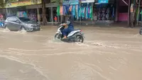 Seorang pengendara sedang genangan air di jalan raya blega, Kabupaten Bangkalan, Rabu, 9 Desember 2020.