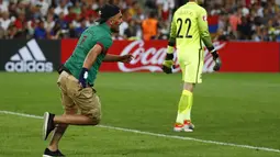 Suporter Portugal berlari memasuki lapangan mengejar Ronaldo saat Portugal melawan Polandia pada perempat final Piala Eropa 2016 di Stade Velodrome, Marseille, (1/7/2016) dini hari WIB. (REUTERS/Kai Pfaffenbach)