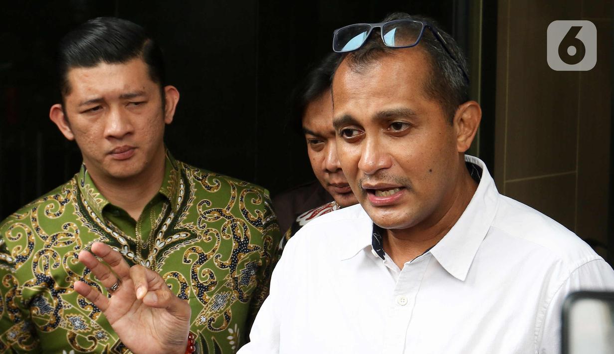 Wakil Menteri Hukum dan HAM (Wamenkumham) Edward Omar Sharif Hiariej (tengah) menjawab pertanyaan wartawan usai memberikan klarifikasi di Gedung Merah Putih KPK, Jakarta, Senin (23/3/2023). (Liputan6.com/Herman Zakharia)