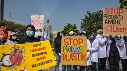 Puluhan aktivis dan peneliti dari Ecological Observation and Wetlands Conservation (ECOTON), sebuah lembaga kajian ekologi dan konservasi lahan, melangsungkan aksi tolak sampah plastik di Surabaya, Rabu 16 Juli 2025. (Juni KRISWANTO/AFP)