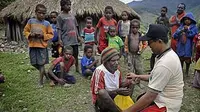 Petugas Puskesmas Illu Saparuddin (kanan) memberikan layanan kesehatan kepada warga yang tinggal di pedalaman kampung Nioga, Distrik Illu, Puncak Jaya, Papua.(Antara)