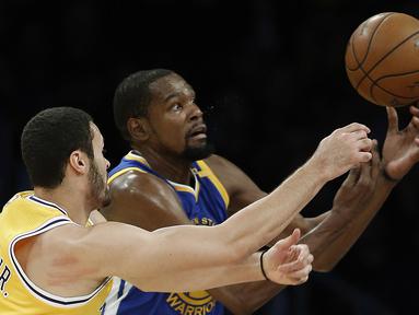 Pemain Los Angeles Lakers, Larry Nance Jr. (kiri) berebut bola dengan pemain Golden State Warriors, Kevin Durant (kanan) pada laga NBA basketball game di Los Angeles, (4/11/2016).  (AP /Alex Gallardo)
