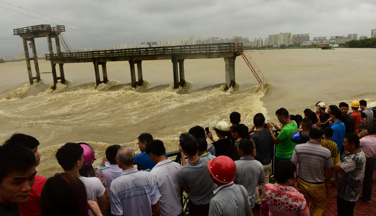 Sejumlah warga berdiri di dekat sungai setelah Topan Sarika menghantam kawasan hit Qionghai, Provinsi Hainan,  Tiongkok, (18/10).  (REUTERS/Stringer) 