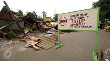Sebuah plang penutup jalan terpampang di Jalan Rawajati Barat, Jakarta, Jumat (2/9). Pasca penggusuran pemukiman di bantaran rel kereta kawasan Rawajati, sejumlah warga masih memilih bertahan tinggal di lokasi. (Liputan6.com/Helmi Fithriansyah)