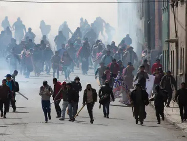 Ratusan petani daun koka membubarkan diri saat polisi melepaskan gas air mata di La Paz, Bolivia, Selasa (21/2). Mereka protes kebijakan baru Presiden Evo Morales terkait petani daun koka. (AP Photo / Juan Karita)