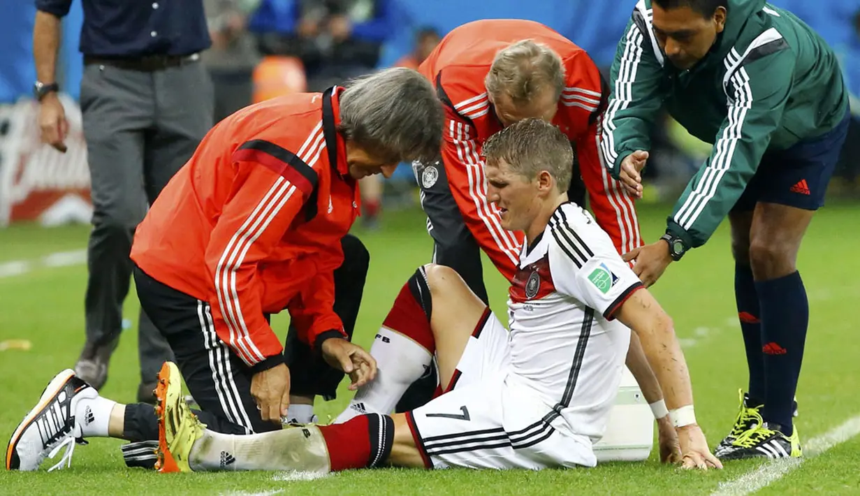 Pemain tengah Timnas Jerman, Bastian Schweinsteiger, harus mendapat perawatan tim medis akibat cedera saat berlaga kontra Aljazair di Stadion Beira Rio, Porto Alegre, (1/7/2014). (REUTERS/Stefano Rellandini) 