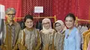 Ibu dua anak ini juga tampil dengan kebaya biru brokat yang terlihat lebih longgar serta menyematkan bros di bagian dada. Lalu dipadukan kain batik lilit sebagai bawahan. Ia pun membawa mini bag mutiara. [@ikat_ind]