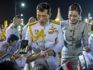 Raja Maha Vajiralongkorn dan Ratu Suthida menyapa pendukungnya di Bangkok, Thailand, Minggu (1/11/2020). Di bawah tekanan yang meningkat dari pengunjuk rasa yang menuntut reformasi pada monarki, Raja dan Ratu Thailand bertemu dengan ribuan pendukung yang memujanya. (AP Photo/Wason Wanichakorn)