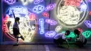 Sejumlah pengunjung berfoto dengan latar belakang seni instalasi cahaya yang berjudul "Halo Park" di Chaoyang Park, Beijing (7/5). Pameran ini merupakan karya dari tim seni dan multimedia kreatif internasional. (AFP/Fred Dufour)