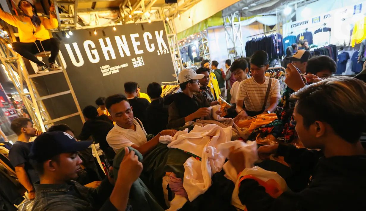 Pengunjung memilih kaus pada JakCloth Year End Sale 2019 di Plaza Tenggara GBK Senayan, Jakarta, Kamis (26/12/2019). Sebanyak 400 clothing line lokal dan brand internasional, lomba permainan kekinian hingga cuci sepatu gratis ramaikan sambut libur akhir tahun. (Liputan6.com/Fery Pradolo)
