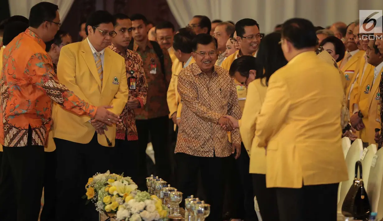 Wakil Presiden Jusuf Kalla (tengah) didampingi Ketum Golkar Airlangga Hartarto saat menghadiri penutupan Munaslub Golkar di Jakarta, Rabu (20/12). Jusuf Kalla mengenakan batik berwarna emas saat menghadiri acara tersebut. (Liputan6.com/Faizal Fanani)