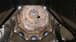 Seorang teknisi bergelantungan di tali saat ia memeriksa kubah katedral Basilica di Santa Maria del Fiore di Italia (11/1). Bangunan ini diarsiteki oleh Filippo Brunelleschi. (Claudio Giovannini/Opera del Duomo press office via AP)