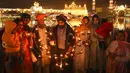Umat Sikh menyalakan lampu tanah di Kuil Emas yang diterangi pada peringatan kelahiran Guru Nanak di Amritsar, India, 19 November 2021. Guru Nanak adalah Guru Sikh pertama dan pendiri Sikhisme. (AP Photo/Prabhjot Gill)
