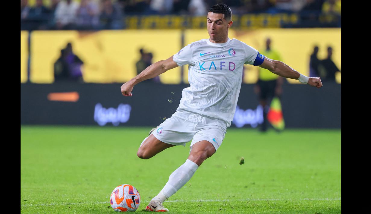Pemain Al Nassr, Cristiano Ronaldo, menendang bola ke gawang Al Riyadh dalam laga pekan ke-16 Saudi Pro League 2023/2024 yang digelar di Al Awwal Park, Sabtu (9/12/2023) dini hari WIB. Ronaldo membuka keunggulan Al Nassr lewat golnya pada menit ke-33. (AFP/Fayez Nureldine)