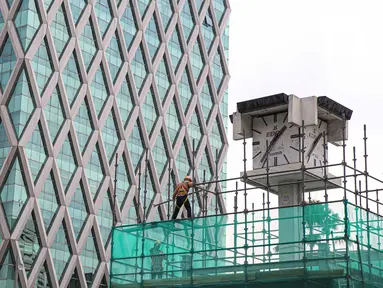 Pekerja memasang penutup di Tugu Jam Thamrin, Jakarta, Kamis (18/11/2021). PT MRT Jakarta (Perseroda) dalam waktu dekat akan memindahkan sementara Tugu Jam Thamrin di Jakarta Pusat yang merupakan bangunan cagar budaya. (Liputan6.com/Faizal Fanani)