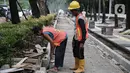 Pekerja menyelesaikan proyek revitalisasi pedestrian di kawasan Jalan Pattimura, Jakarta, Rabu (8/6/2022). Dinas Bina Marga DKI Jakarta merevitalisasi pedestrian dengan memperlebar menjadi tiga meter sehingga cukup luas untuk memberikan kenyamanan para pejalan kaki. (Liputan6.com/Faizal Fanani)