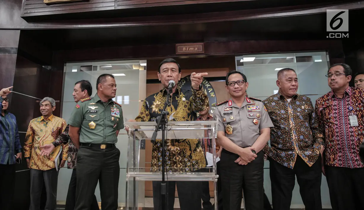 Menko Polhukam Wiranto (tengah) memberi keterangan usai rapat koordinasi terkait polemik pengadaan senjata di Kemenkopolhukam, Jakarta, Jumat (6/10). Dalam rapat tersebut, Dirjen Bea Cukai Heru Pambudi juga turut hadir. (Liputan6.com/Faizal Fanani)