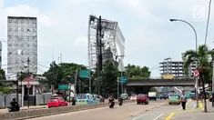 Sejumlah pengendara melintas di dekat papan reklame yang hampir roboh di kawasan Terminal Kampung Melayu, Jakarta (2/10). Hujan deras disertai angin kencang yang mengguyur Ibu Kota kemarin membuat papan reklame ini hampir roboh.(Liputan6.com/Helmi Afandi)