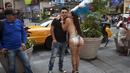 Seorang wanita berpose sambil mencium pipi seorang wisawatan di ruas jalan Times Square, New York,AS, Selasa (18/8/2015).  Pemerintah setempat telah melarang kegiatan yang dianggap meresahkan tersebut. (REUTERS/Carlo Allegri)