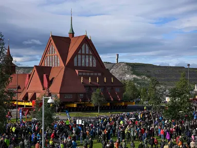 Orang-orang berkumpul untuk menyaksikan pemindahan Gereja Kayu Kiruna di Kiruna, Swedia, pada 19 Agustus 2025. (Jonathan Nackstrand/AFP)