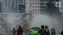 Petugas pemadam kebakaran (Damkar) melakukan penyemprotan cairan disinfektan di sepanjang jalan Thamrin-Sudirman, Jakarta, Sabtu (28/3/2020). Penyemprotan menggunakan mobil pemadam kebakaran tersebut bertujuan untuk mengantisipasi penyebaran Virus Corona (COVID-19). (merdeka.com/Imam Buhori)