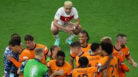 Ekspresi pemain timnas Turki, Baris Alper Yilmaz saat menyaksikan para pemain Belanda merayakan kemenangan laga perempat final Euro 2024 di Olympiastadion Berlin pada 6 Juli 2024 atau Minggu 7 Juli 2024 dini hari WIB. (Ronny HARTMANN/AFP)