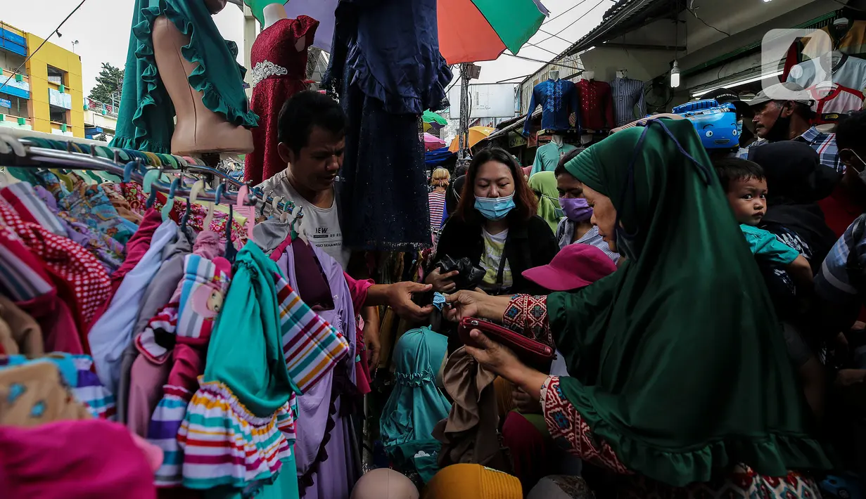 Pengunjung membeli busana muslim yang dijual di Pasar Tanah Abang, Jakarta Pusat, Minggu (2/5/2021). Pusat Grosir Pasar Tanah Abang ramai didatangi pengunjung yang berbelanja menjelang Lebaran dengan berdesak-desakan tanpa jaga jarak. (Liputan6.com/Johan Tallo)