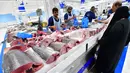 Suasana saat pembeli memilih potongan ikan yang dijual di pasar ikan Dubai, Uni Emirat Arab, Kamis (29/3). (GIUSEPPE CACACE/AFP)