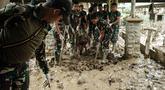 Personel Tentara Nasional Indonesia (TNI) dari YONIF TP 853/BRB, Aceh Timur, membersihkan lumpur di Rumah Sakit Daerah di Aceh Tamiang, pada Selasa 16 Desember 2025, setelah banjir bandang sekitar tiga minggu lalu. Lumpur tebal di banyak lorong dan genangan air dampak banjir bandang yang masih menutup sebagian besar dari Rumah Sakit Daerah Aceh Tamiang. (Yasuyoshi Chiba/AFP)