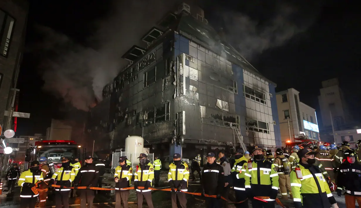 Polisi berjaga di lokasi kebakaran gedung pusat kebugaran berlantai delapan  di Jecheon, Korea Selatan, Kamis (21/12). Jumlah korban kebakaran kemungkinan masih bertambah sementara upaya menemukan korban terus berlangsung. (Kim Hyung-woo/Yonhap via AP)