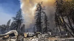 Properti yang hancur tertinggal di belakangnya saat api melahap hutan dekat Midpines, timur laut Mariposa, California (23/7/2022). Api yang bergerak cepat membakar di luar Taman Nasional Yosemite telah memaksa evakuasi, menghanguskan lebih dari 11.500 hektar dan telah menghancurkan beberapa rumah sejak mulai Jumat sore. (AFP/DAVID MCNEW)