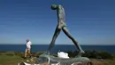 Seorang pengunjung berjalan dekat sebuah patung bagian dari pameran Sculpture by the Sea di Sydney, Australia, Jumat (19/10). Sementara itu, "Sculpture by the Sea" merupakan pameran tahunan yang mulai digelar sejak 1996 silam. (PETER PARKS/AFP)