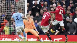 Pemain Manchester United, Bruno Fernandes (dua kanan) menendang bola yang membuahkan gol ke gawang Manchester City yang dijaga oleh Ederson dalam pertandingan lanjutan Liga Inggris 2022/2023. (AP Photo/Dave Thompson)