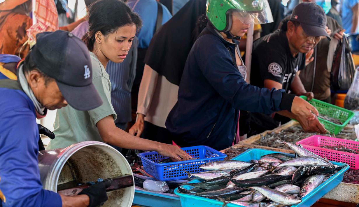 Pelabuhan perikanan di Bali menjadi basis penting untuk mengelola sumber daya laut yang berkelanjutan. Tampak dalam foto, orang-orang membeli ikan di pasar di pantai Kedonganan dekat Denpasar, Bali, pada Jumat 10 April 2026. (SONNY TUMBELAKA/AFP)