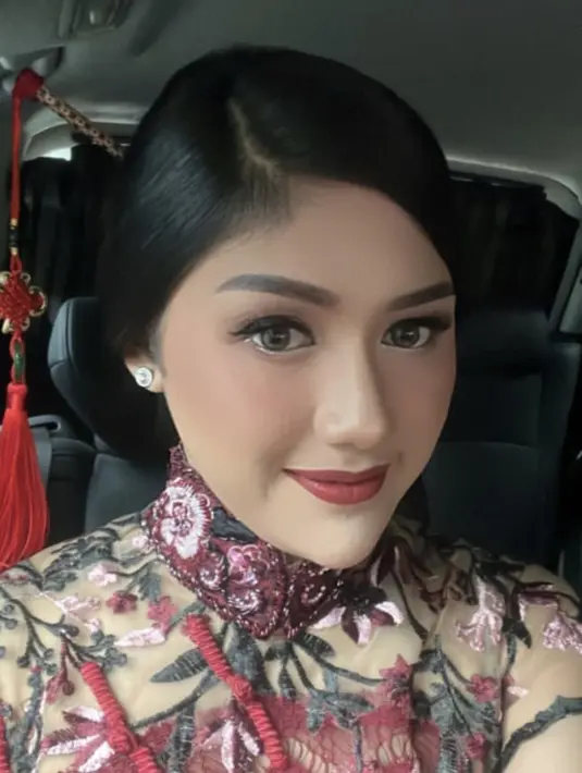 Untuk makeup,MUA Hepi Herviani Wattimena memoles wajah Erina dengan makeup glam, terlihat dari lipstik merah matte yang senada dengan blush on, dan alis yang tegas serta eyeshadow hitamnya. (@hepidavid)