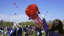 Seorang wanita berusaha menerbangkan layang-layang pada Festival Blossom Kite (Festival Layang-Layang) di dekat Monumen Washington di Washington, D.C., Amerika Serikat, Sabtu (31/3). Festival ini untuk menyambut bunga sakura bermekaran. (Eva HAMBACH/AFP)