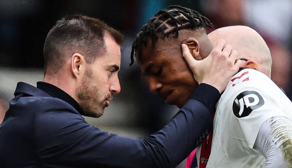 Bek Southampton, Armel Bella-Kotchap (kanan) dihibur pelatih Ruben Selles setelah ditarik keluar akibat cedera saat menghadapi Tottenham Hotspur pada laga Liga Inggris 2022/2023 di St Mary's Stadium, Southampton (18/3/2023). Baru membela Southampton pada awal musim 2022/2023, Armel Bella-Kotchap yang berpaspor Jerman mempunyai potensi menjadi bek hebat. Saat ini ia tengah diincar Eintracht Frankfut dan Liverpool. (AFP/Adrian Dennis)
