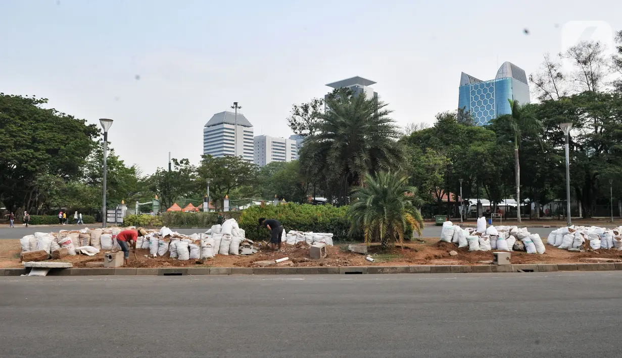 Pekerja menyelesaikan pembuatan sumur resapan di kawasan Monas, Kamis (21/11/2019). Sudin Perindustrian dan Energi Kota Administrasi Jakpus membuat sekitar 70 titik sumur resapan di taman kawasan Monas guna meminimalisir genangan sekaligus menampung air saat hujan. (merdeka.com/Iqbal Nugroho)