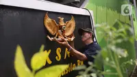 Warga memasang lambang burung Garuda Pancasila di sebuah tembok di di Kampung Pancasila, Karang Tengah, Kota Tangerang, Selasa (1/6/2021). Sejumlah kegiatan diadakan warga, Komunitas Taman Potret dan TNI ini untuk memperingati Hari kelahiran Pancasila. (Liputan6.com/Angga Yuniar)