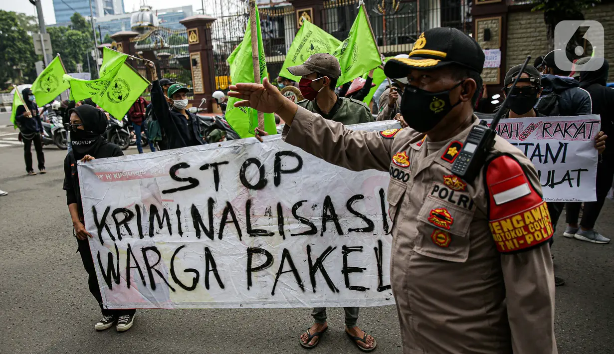 Polisi melakukan pengamanan saat massa yang tergabung dalam Rukun Tani Sumberejo Pakel menggelar aksi di depan Mabes Polri, Jakarta, Kamis (17/6/2021). Massa meminta negara hadir dalam pemenuhan hak atas ruang hidup terkait perampasan oleh PT Bumi Sari. (Liputan6.com/Faizal Fanani)