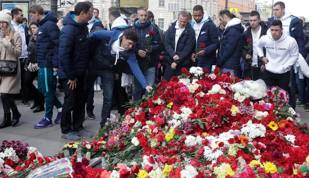 Sejumlah orang meletakkan bunga di dekat stasiun kereta bawah tanah St. Petersburg sebagai bentuk belasungkawa, Rusia, Selasa (5/4). Dikabarkan 10 orang meninggal dalam tragedi tersebut. (AP Photo)