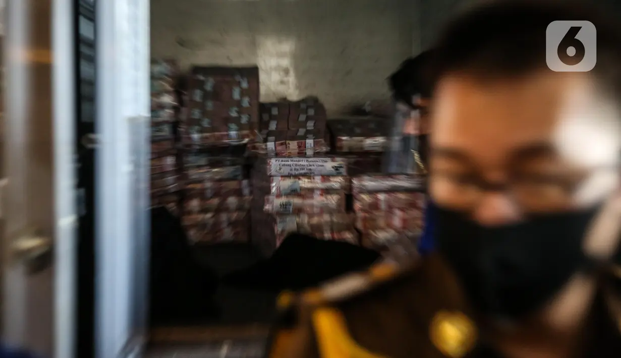 Tumpukan uang diturunkan dari mobil saat rilis eksekusi barang bukti Honggo Wendratno di Kejaksaan Agung RI, Jakarta, Selasa (7/7/2020). Kejagung menyita barang bukti uang Honggo Wendratno sebesar Rp 97 miliar. (Liputan6.com/Faizal Fanani)