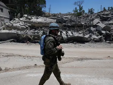Seorang pasukan penjaga perdamaian Perserikatan Bangsa Bangsa (PBB) asal Spanyol melewati sebuah rumah yang hancur dalam bentrokan antara Hizbullah dan militer Israel di desa Dibbine, Lebanon Tenggara, Jumat 5 Juni 2026. (AP Photo/Hussein Malla)