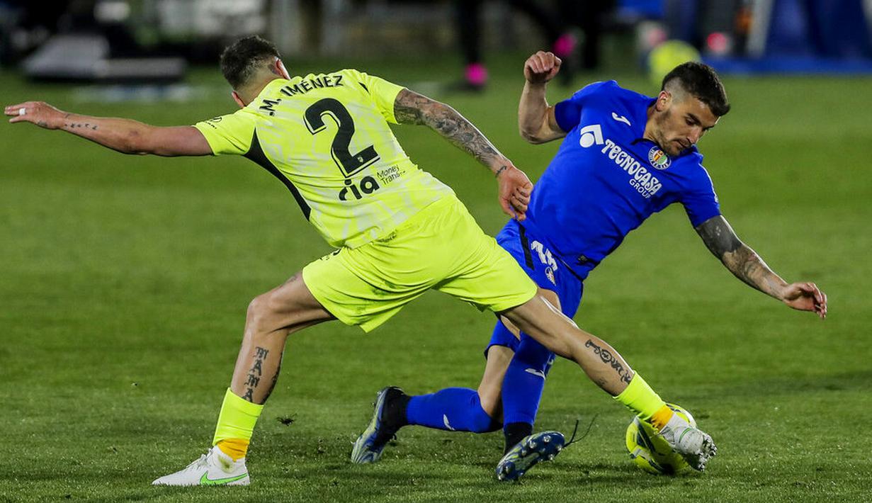 Pemain Atletico Madrid, Jose Gimenez, berebut bola dengan pemain Getafe, Mauro Arambarri, pada laga Liga Champions di Stadion Alfonso Perez, Sabtu (13/3/2021). Kedua tim bermain imbang 0-0. (AP/Manu Fernandez)