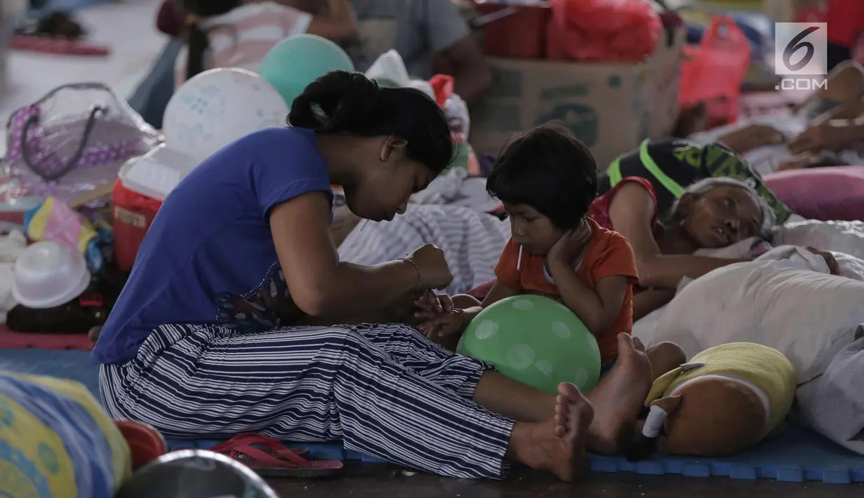 Aktivitas warga di lokasi pengungsian di GOR Suweca, Klungkung, Bali, Selasa (26/9). Hingga kini tercatat, 57.418 jiwa mengungsi di 357 lokasi menyusul peningkatan aktifitas Gunung Agung yang masih berstatus awas. (Liputan6.com/Gempur M Surya)