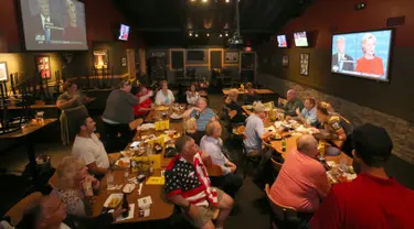 Sekelompok pendukung Donald Trump menyaksikan debat pertama kedua capres AS dari Partai Republik dan Partai Demokrat, Donald Trump dan Hillary Clinton dari layar televisi di sebuah restoran di Ohio, Amerika Serikat, Senin (26/9). (REUTERS/Aaron Josefczyk)